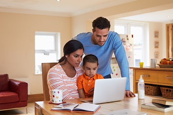 Family with laptop at dining table