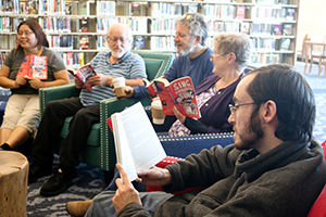 Five people discussing a book in a Book Group