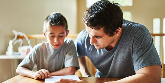 Man helping boy with his homework