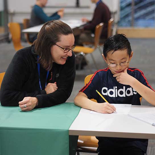 A volunteer helps a child with homework