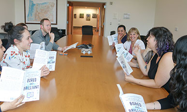 A book group meets at the large table in the Board Room