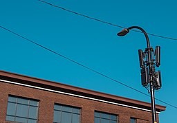 A small cell facility on a street light in an urban setting