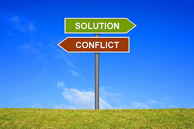 A road sign with one arrow pointing to solution and the other arrow pointing toward conflict