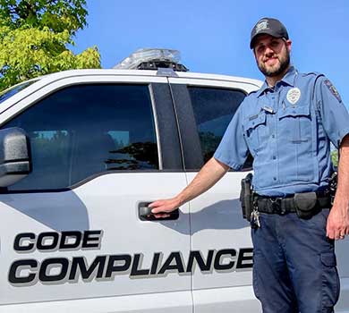 Code Compliance Officer Joey Blanc poses with his vehicle