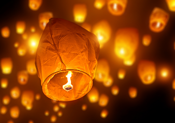 A paper sky lantern with an open flame