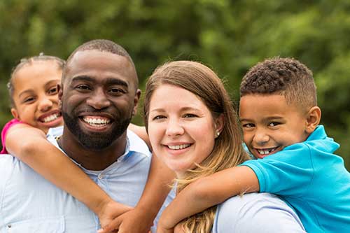 A multiracial family poses outdoors for a photo