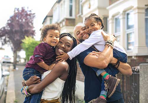 A family poses in front of their neighborhood