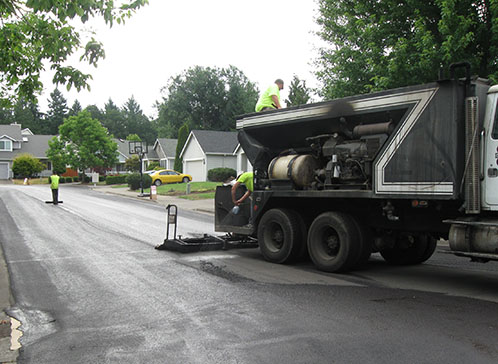 Slurry seal being applied to roadway