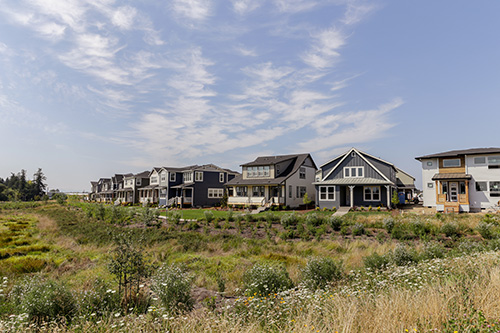 Row of new houses behind a field in South Hillsboro community