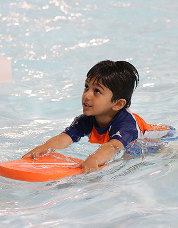 A child swims with a kickboard