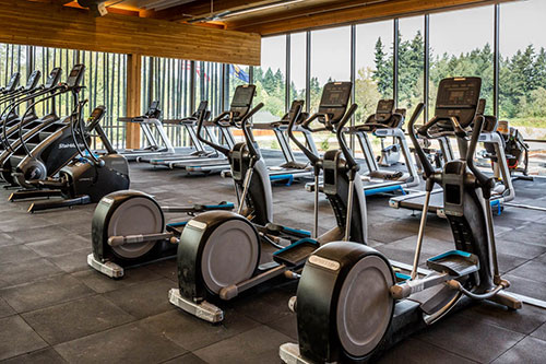 Fitness equipment at Hidden Creek Community Center, including stair machines, ellipticals, stationary bikes