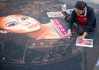 Jennifer Rippassa creates a chalk art self portrait at La Strada