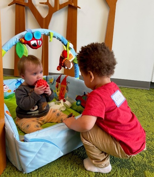 Two young community members play together in the kids club