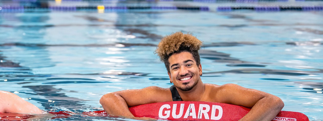 A lifeguard in the pool with a flotation device