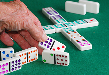 Senior holding a domino.