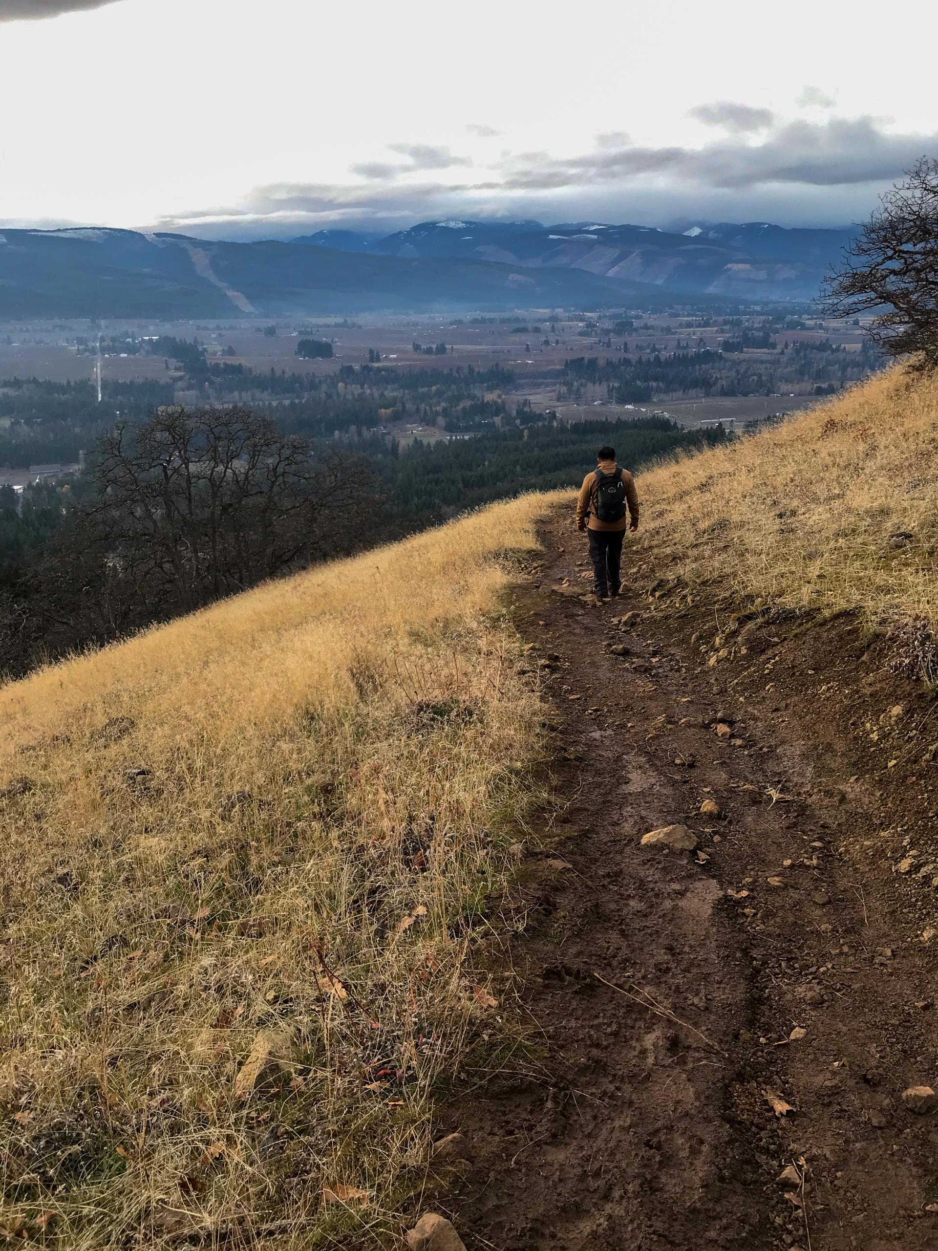 Rahim hiking on a trail overlooking a town