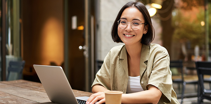 Woman using laptop at cafe table