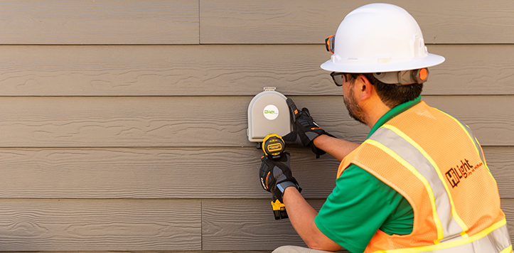 HiLight worker installing tap box on side of house