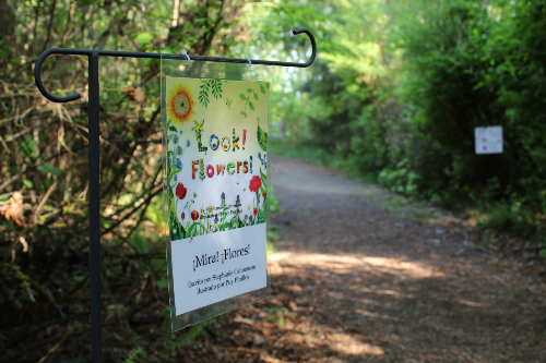 A nature trail at Jackson Bottom with a colorful sign that says "Look! Flowers!"