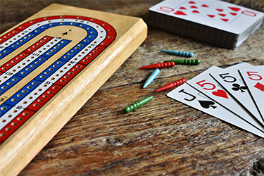 Cribbage board and pegs and a deck of cards.