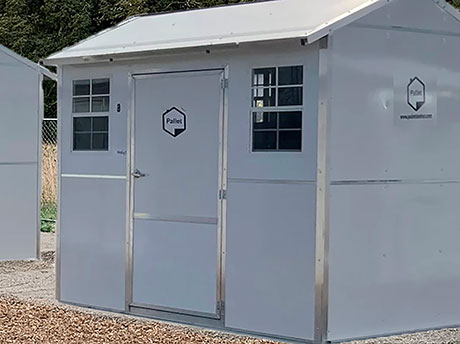 A 64 square foot temporary pallet shelter with a door and windows