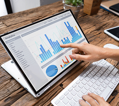 Computer keyboard and screen displaying charts & data