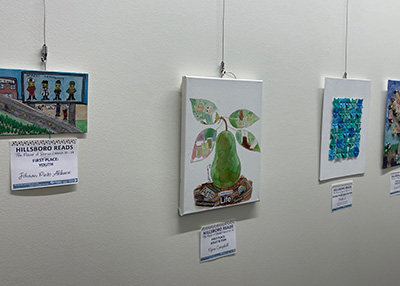 Three pieces of community art hanging in Brookwood Library