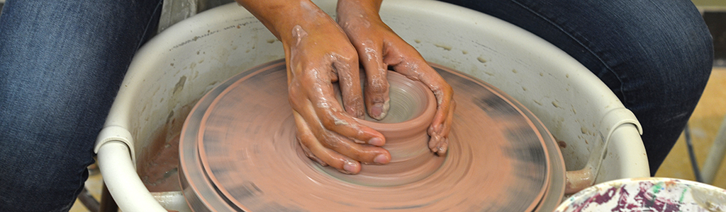 Student working at the potter's wheel