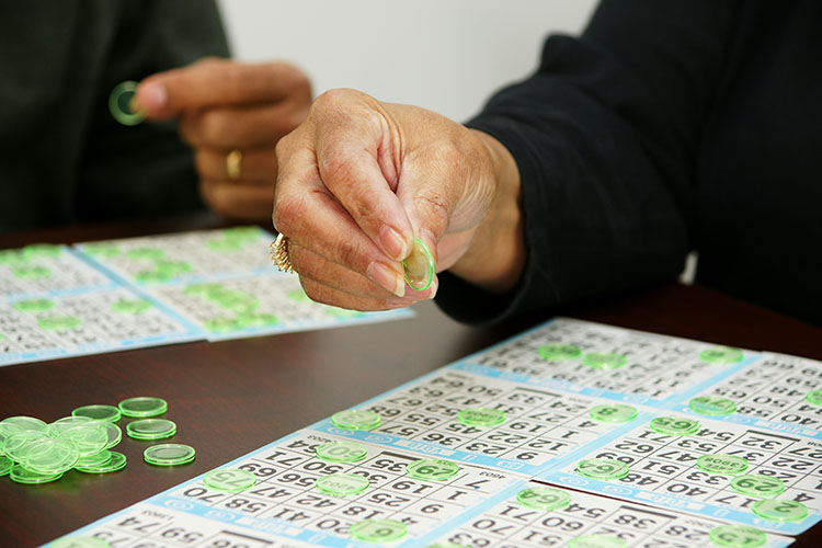 Seniors playing Bingo with multiple cards.