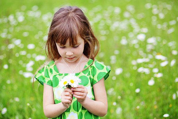 Young girl holding a bouquet of flowers.