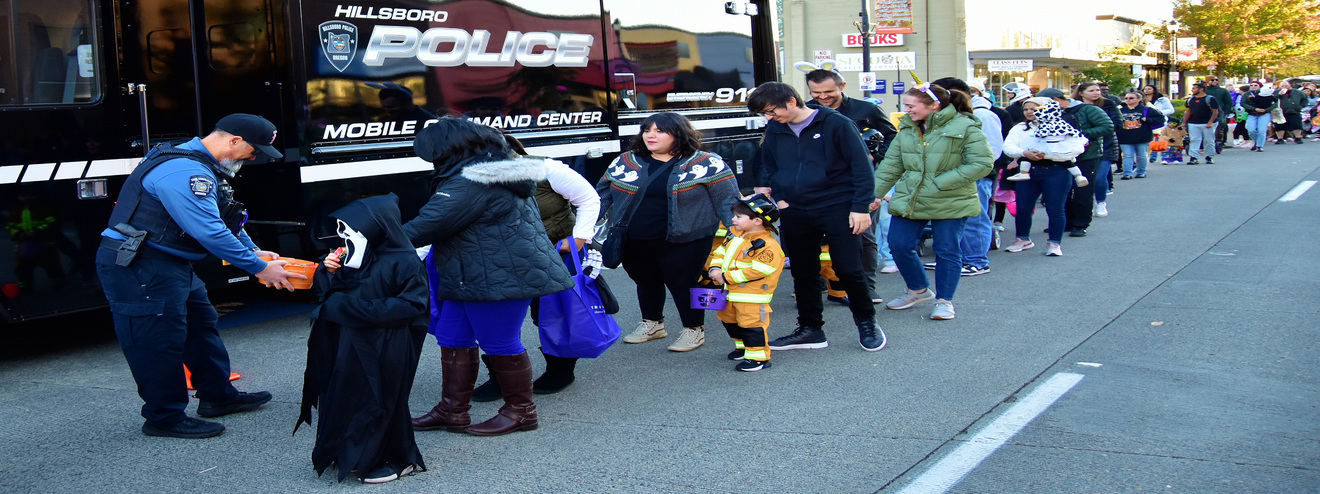 Community Members lines up outside of HPD vehicle getting candy